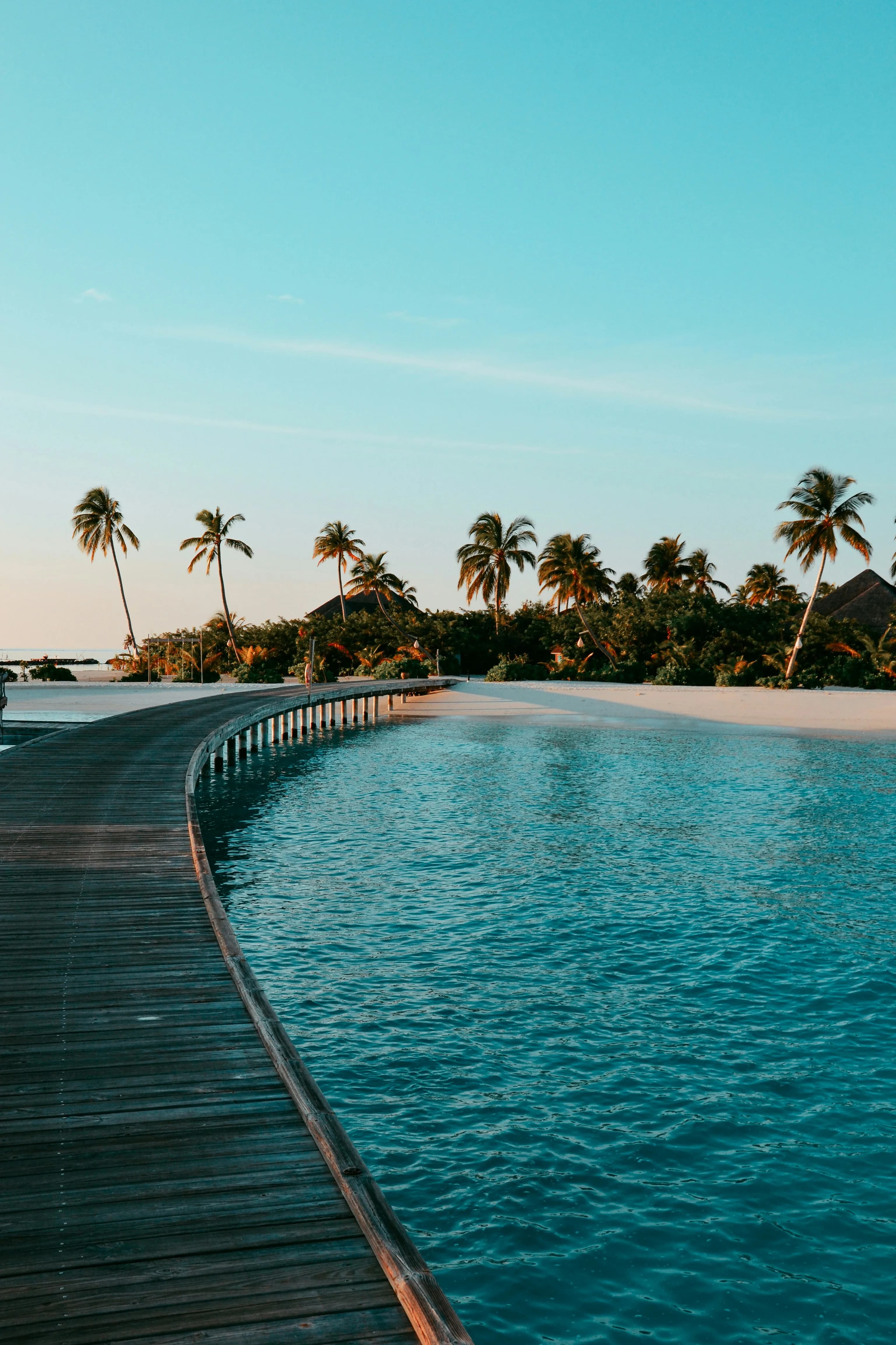 Tropical boardwalk over turquoise water in the Maldives